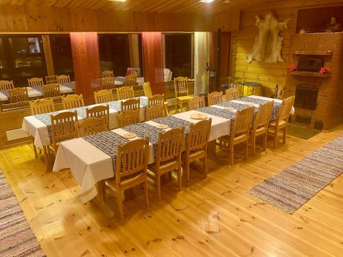 a dining room with tables and chairs and a fireplace at Villa Rapakivi in Heinola
