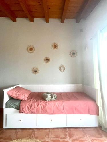 a white bed with a pink comforter in a room at B&B Casa Loré D'or in Alora