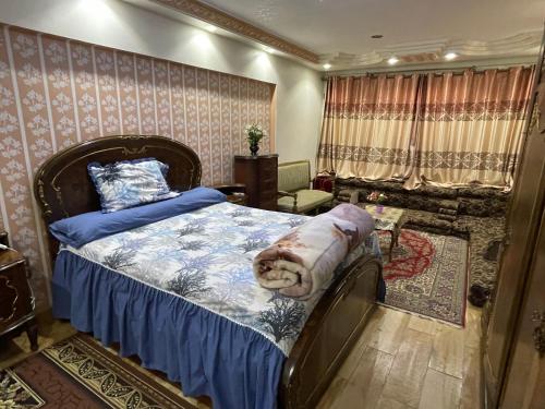 Schlafzimmer mit einem Bett mit blauer Decke in der Unterkunft شقة مطلة علي قناة السويس701 in Port Said