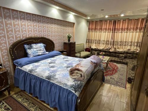 a bedroom with a bed with a blue comforter at شقة عائليه 701مطلة علي قناة السويس والبحر in Port Said
