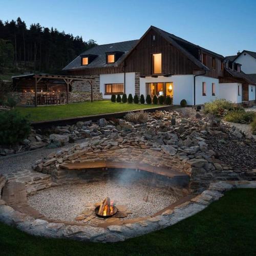 a fire pit in a yard in front of a house at Chalupa Adamův Dvůr in Zdíkov