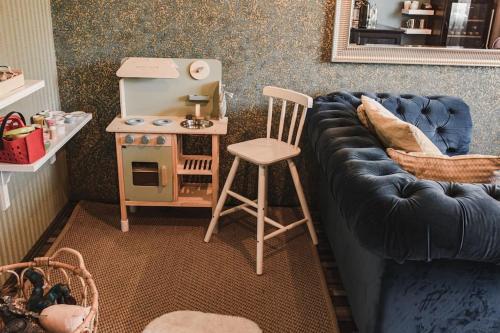 a living room with a blue couch and a stool at Chalupa Adamův Dvůr in Zdíkov
