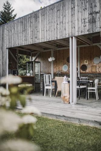 a wooden porch with a table and chairs and a cat sitting on it at Chalupa Adamův Dvůr in Zdíkov
