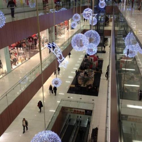 people walking in a shopping mall with blue umbrellas at Komfortný apartmán A407 v centre NR, bez kuchyne, parkovisko zdarma in Nitra