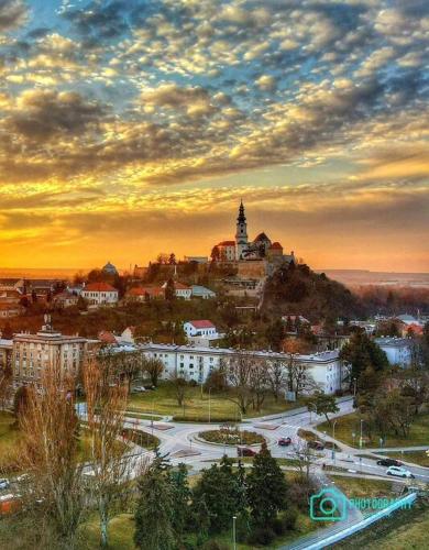 a city with a church on top of a hill at Komfortný apartmán A407 v centre NR, bez kuchyne, parkovisko zdarma in Nitra
