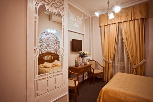 ein Hotelzimmer mit einem Bett und einem Tisch sowie einem Schlafzimmer in der Unterkunft Old Vienna in Sankt Petersburg