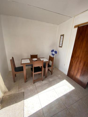 uma sala de jantar com uma mesa de madeira e cadeiras em El três em Chuy