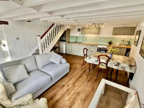 a living room with a couch and a table at 2 Stable Cottage, Llanbethery in Llancarfan