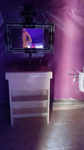 einen Spiegel an einer rosa Wand mit einem weißen Tisch in der Unterkunft Luxury trek desert camp in Merzouga