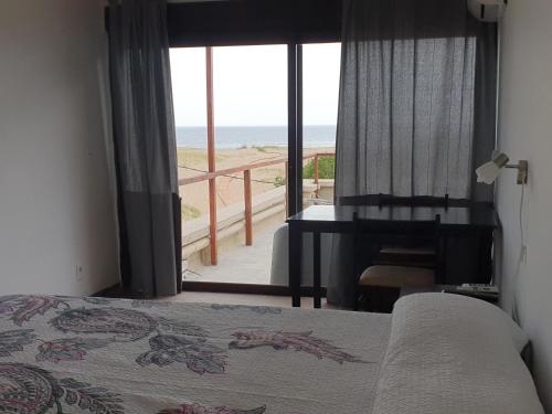 1 dormitorio con cama y vistas a la playa en Hotel Playa Chihuahua, en Punta del Este