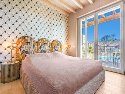 ein Schlafzimmer mit einem Bett und einem großen Fenster in der Unterkunft Lemonhouse Bezzuglio in Toscolano-Maderno
