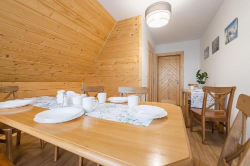 uma sala de jantar em madeira com uma mesa e cadeiras em Sielanka w górach em Gliczarów Górny