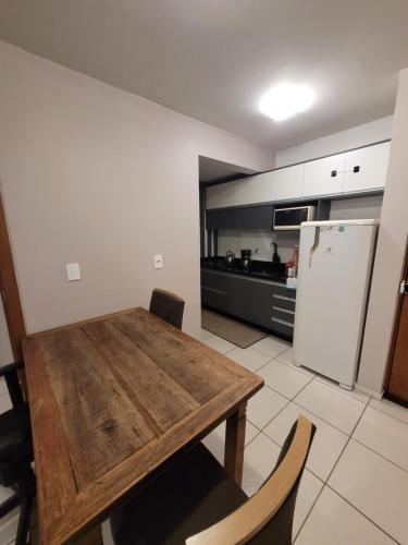 uma cozinha com uma mesa de madeira e um frigorífico em Apartamento centro Efapi ideal para trabalho ou estudo em Chapecó