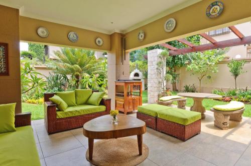 d'une terrasse avec un mobilier vert et une table. dans l'établissement Villa Toledo, à Pretoria
