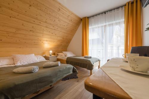 um quarto com 2 camas e uma grande janela em Sielanka w górach em Gliczarów Górny