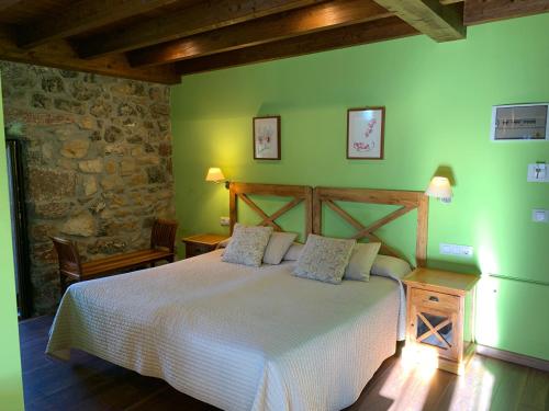 1 dormitorio con cama y pared verde en Hotel El Quintanal, en Bode