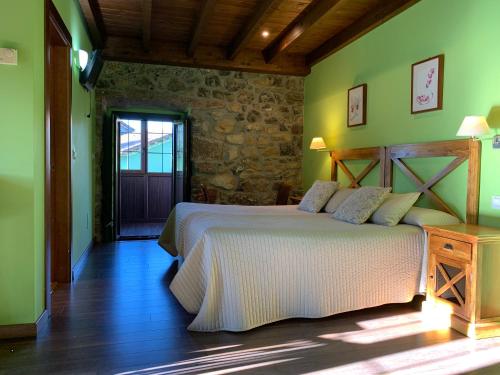 Hotel El Quintanal في Bode: غرفة نوم بسريرين في غرفة بجدران خضراء
