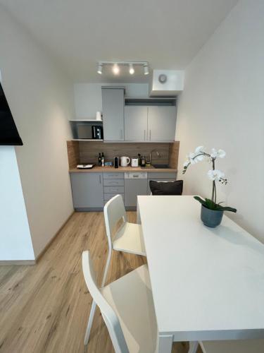 eine Küche mit einem weißen Tisch und weißen Stühlen in der Unterkunft #Family & Friends# Ruhig, grün, gleich in der City in Wien