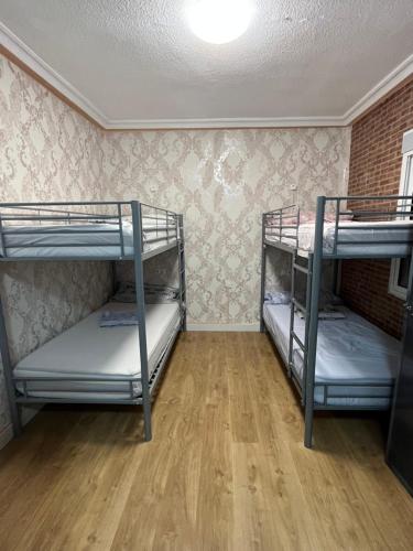 two bunk beds in a room with a wooden floor at Acho Rancho in Murcia