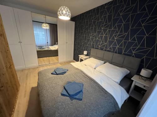a bedroom with a large bed with blue towels on it at Apartament Studio Centrum in Koszalin