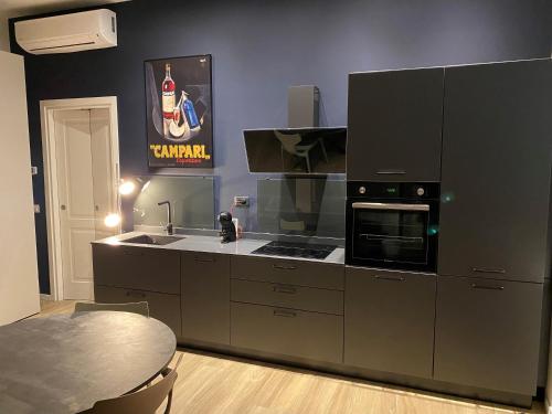 a kitchen with a stove top oven next to a table at #milanodabere Urban Loft in Milan