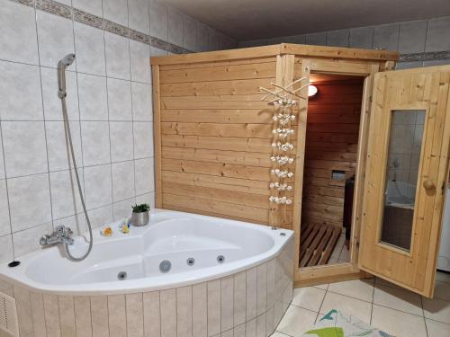a bath tub in a bathroom with a wooden wall at Piece of Greece in Neunburg vorm Wald