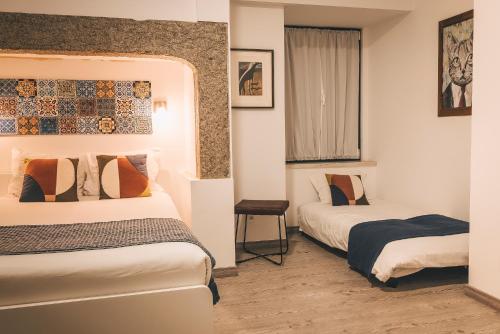 een hotelkamer met 2 bedden en een raam bij Walk'in Sodré in Lissabon