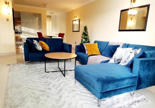 a living room with a blue couch and a table at InstaHomes by Tru - Villa in Blantyre
