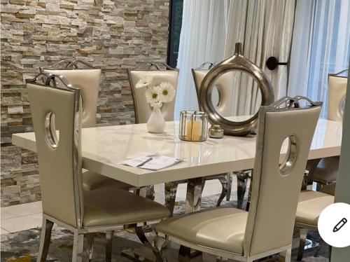 mesa de comedor blanca con sillas y espejo en Ndaba Golf Lodge on 13th hole, en East London