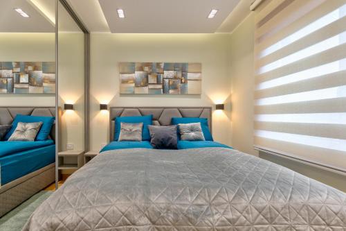 a bedroom with a blue bed with blue pillows at Apartment Papillon 5 in Zlatibor