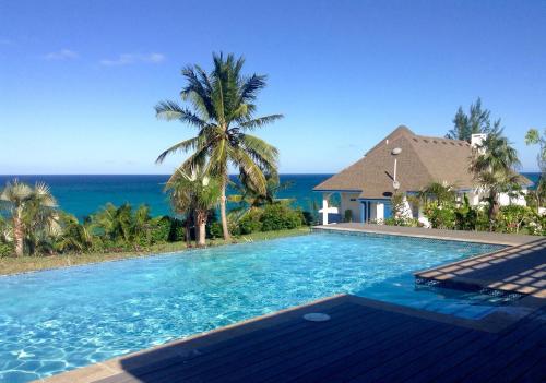 a swimming pool with a view of the ocean at Tourmaline home in Governorʼs Harbour