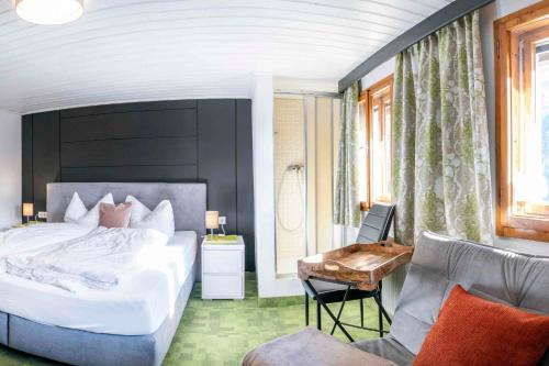 1 dormitorio con 1 cama blanca grande y 1 silla en Pension Grünwald en Sölden