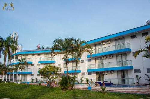 a large building with palm trees in front of it at Centro Vacacional Las Palmas in San José del Guaviare