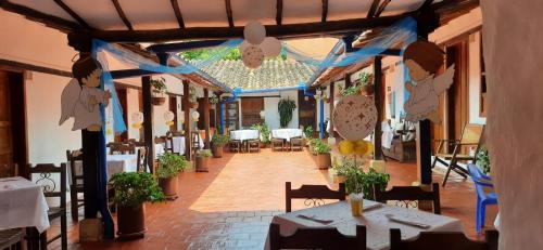 a dining room with tables and chairs and a ceiling at Hotel Casa del Marquez de Bahichala in Barichara