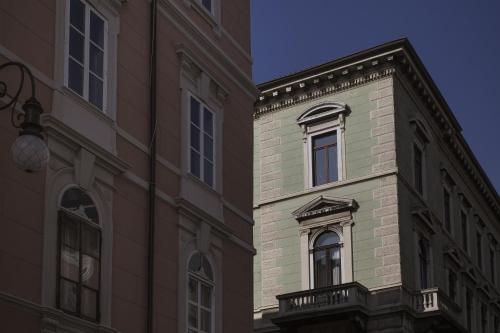 a tall brick building with a window on the side of it at Seven Historical Suites in Trieste