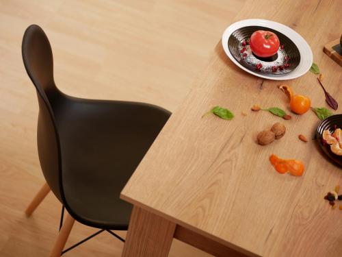 a table with a black chair and a plate of food at Altavista mountain apartment in Samokov