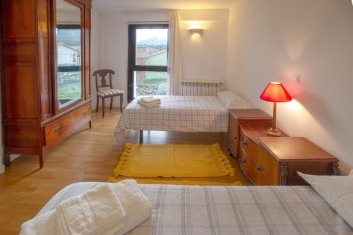 1 dormitorio con 2 camas, vestidor y ventana en Casa junto a Reserva del Saja, bosque y montaña en Arenas de Iguña