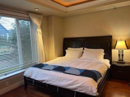 a bedroom with a bed and a window at Lucky suite, two-bedroom suite in Richmond close to YVR in Richmond