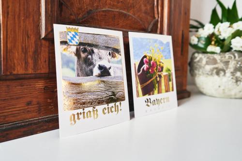 três cartas sentadas numa mesa com uma foto de uma vaca em Gästezimmer ROSS em Hohenlinden