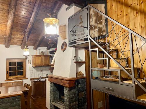 una cucina con scala e un camino in una stanza di Maison Vollon a Brusson