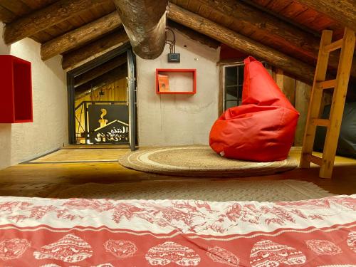 una camera da letto con cuscino rosso sul pavimento di Maison Vollon a Brusson