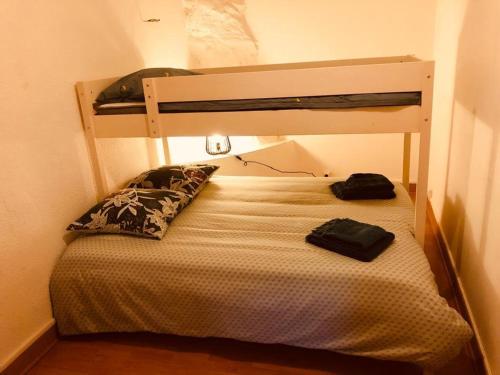a small bedroom with a bunk bed with a pillow at Chaîne des puys chez William in Royat