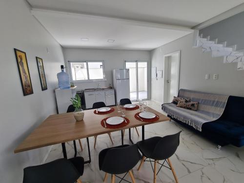 cocina y sala de estar con mesa y sillas en Recanto Brisa e Mar, en Palhoça