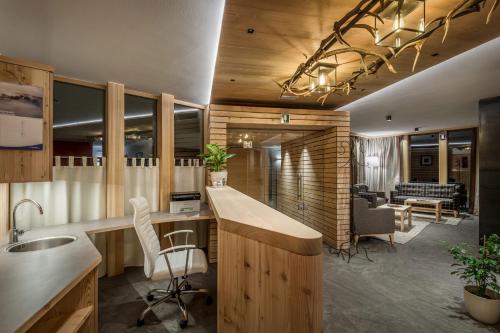 an office with a kitchen with a desk and chairs at Chalet Martina Apartments in San Vigilio Di Marebbe