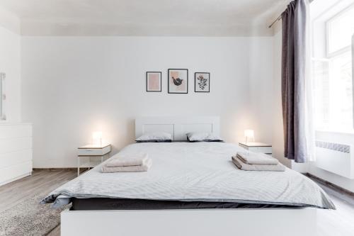 - une chambre blanche avec un grand lit et deux lampes dans l'établissement Lovely Apartments Heart of Prague, à Prague