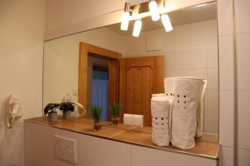 a bathroom with towels on a counter in front of a mirror at Landhaus-Appartements Warraich in Schladming