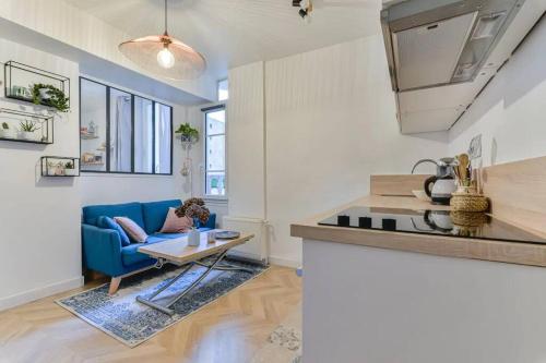 a living room with a blue couch and a table at Joli appartement bois de Vincennes, metro 1, rer A in Vincennes