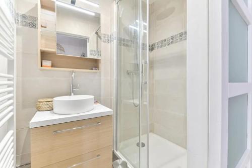 a bathroom with a glass shower and a sink at Joli appartement bois de Vincennes, metro 1, rer A in Vincennes