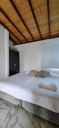 Cette chambre comprend un grand lit et un plafond en bois. dans l'établissement Apartaestudio de paso aeropuerto, à Girón