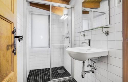 a white bathroom with a sink and a shower at Fidjeland Fjellgrend in Fidjeland